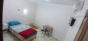 a small bedroom with a bed and a tv at Hostel 1er novembre khenchela in Khenchela