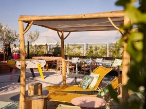 a patio with tables and chairs on a roof at Mama Shelter Roma in Rome