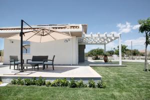 a patio with two chairs and an umbrella at La Giara Guest House in Marina di Modica