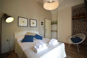 1 dormitorio con 1 cama con almohadas y toallas azules en Locanda Fra Diavolo en Diano Marina