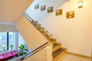 eine Treppe in einem Haus mit rosa Möbeln in der Unterkunft FabHotel Tan Square - Nr Eon IT Park in Pune