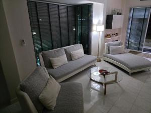 a living room with two couches and a table at Pranaluxery Pool Villa 1 in Pran Buri