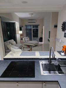 a kitchen with a sink and a living room at Pranaluxery Pool Villa 1 in Pran Buri