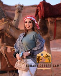 a woman standing in front of a picture of a camel at Lunara Desert Camp in Wadi Rum