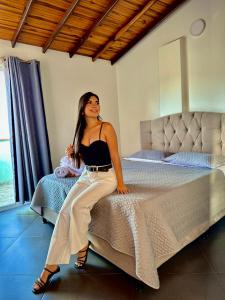 a woman sitting on a bed in a room at Apartamento con vista a San Gil en excelente ubicación in San Gil