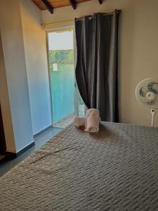 a stuffed animal on a bed with a window at Apartamento con vista a San Gil en excelente ubicación in San Gil