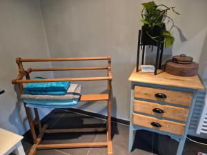 a wooden chair next to a dresser with a plant at LaPause de Fromiée-Gerpinnes in Gerpinnes