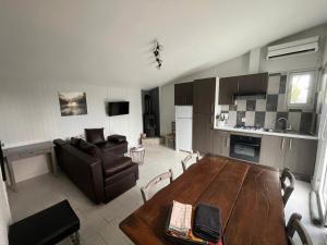 une cuisine et un salon avec une table et un canapé dans l'établissement Gîte Figuier - Village De Gîtes, à Rosières