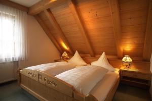 a bed in a room with a wooden ceiling at Landgasthof Löwen in Neubulach