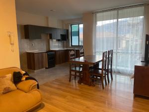 a kitchen and dining room with a table and a couch at Cómodo y acogedor departamento amoblado in Cochabamba
