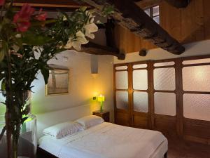ニッツァ・モンフェッラートにあるCasa Piazza del Campanonのベッドルーム1室(ベッド1台付)、花瓶1本