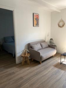 a living room with a couch and a bed at Charmant T2 cosy à Mazamet in Mazamet