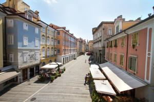 eine leere Stadtstraße mit Sonnenschirmen und Gebäuden in der Unterkunft Ritter'S Rooms & Apartments in Triest