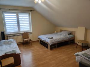 a bedroom with two beds and a window at Dom Weselny Izabela Noclegi in Osiek