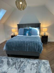 ein Schlafzimmer mit einem großen Bett und blauen Kissen in der Unterkunft Northampton 3 Bed 3 Bathroom New Duplex Apartment in Spinney Hill
