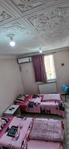 two beds are in a room with a ceiling at hostel 1er novembre khenchela in Khenchela