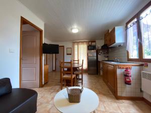 Una cocina y una sala de estar con una mesa y un mostrador. en Gîte Olivier 1 - Village De Gîtes, en Rosières