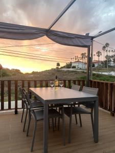 a table with wine glasses and chairs on a deck at Like a Local Guest House in Ericeira