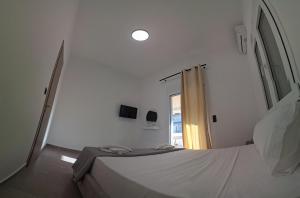 a white bedroom with a bed and a window at Authentic appartement in Aíyira