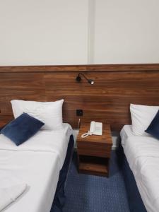 a hotel room with two beds and a telephone at اصول الجوهرة العزيزية Asoul Al Jawhara Al Azizia in Al ‘Azīzīyah