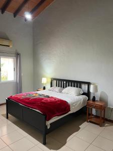 a bedroom with a large bed with a red blanket at Casa única con vista al lago in Hernandarias +23 photos