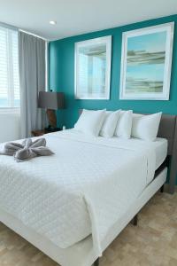 - un grand lit blanc dans une chambre aux murs bleus dans l'établissement Condado Beachfront- Perfect for Families!, à San Juan 19 autres photos
