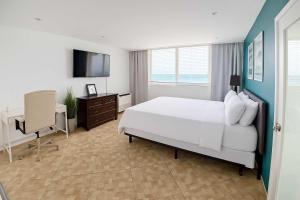 une chambre avec un lit, un bureau et une télévision dans l'établissement Condado Beachfront- Perfect for Families!, à San Juan