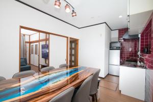 a kitchen and dining room with a wooden table and chairs at NewOpen, Stella Rinku, りんくうタウン駅徒歩10分, 一棟貸切, 関西空港まで6分 in Izumi-Sano