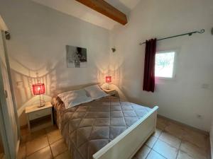 een slaapkamer met een bed en twee lampen op twee tafels bij Gîte Clapas - Village De Gîtes in Rosières