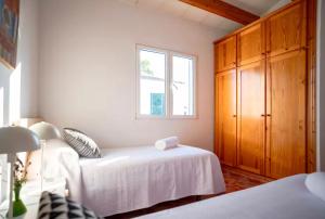 a bedroom with a white bed and a window at Relax en Villa Tranquila in Cala en Blanes