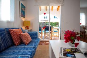 a living room with a blue couch and a table at Relax en Villa Tranquila in Cala en Blanes