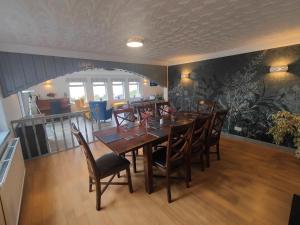 a dining room with a wooden table and chairs at Lochbroom Lodge in Ullapool +47 photos