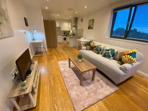 a living room with a couch and a tv at Executive North London Southgate Serviced Apartment - Contractors Ready in East Barnet