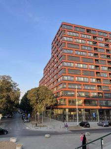 a tall building with a parking lot in front of it at Panorama Studio in Novi Sad