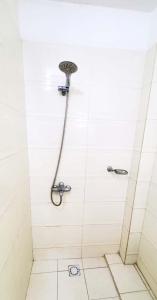 a shower in a white tiled bathroom at Ocean Breeze Suite in Dakar