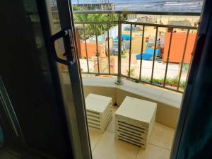 a room with a balcony with a view of a beach at Ocean Breeze Suite in Dakar