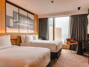 a hotel room with two beds and a desk and a window at Pullman Lima Miraflores in Lima +249 photos