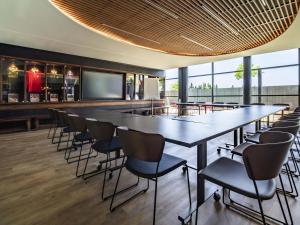 Una gran sala de conferencias con una mesa grande y sillas. en ibis Styles Castelnaudary, en Castelnaudary 120 fotos más