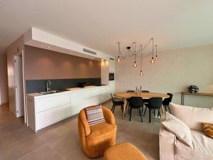a kitchen and living room with a table and chairs at Appartement moderne 2 chambres & 2 parking à Koksijde by La Conciergerie in Koksijde