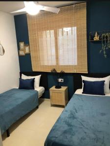 ペニスコラにあるmirador castilloの青い壁の部屋にベッドが2つある