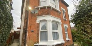 a red brick building with a white window on it at Newly refurbished flat with Free Parking in Purley