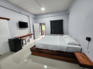 a bedroom with a bed and a desk in it at บ้านร่มไทร Ban Romsai Nadoem Suratthani in Ban Don Yung