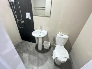 a bathroom with a toilet and a sink at บ้านร่มไทร Ban Romsai Nadoem Suratthani in Ban Don Yung