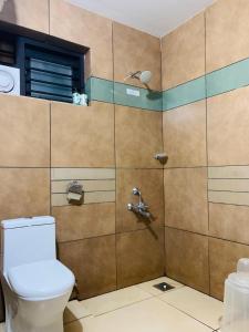 a bathroom with a toilet and a shower at Regalia Wayanad in Kalpetta