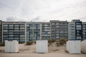 an apartment building on the beach with four electrical boxes in the sand at Seaview Penthouse with Terrace Nieuwpoort in Nieuwpoort