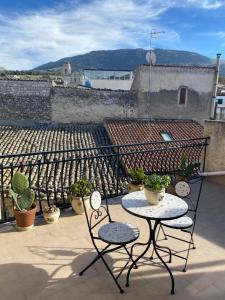 a patio with two chairs and a table on a roof at Casetta in piazza in Palazzo Adriano +7 photos