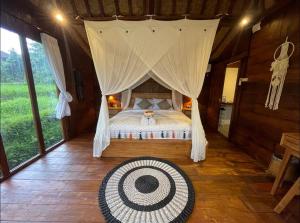 a bedroom with a bed with a mosquito net at Umah Jati Villa in Penginyahan