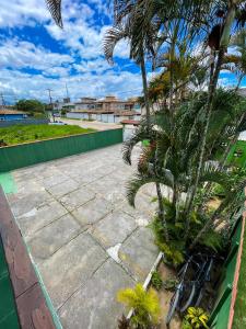ein Fahrrad, das neben einer Mauer mit Palmen parkt in der Unterkunft Pousada Verdes Mares in Rio das Ostras