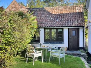 a table and chairs in front of a house at Chapel Cottage Ellicombe in Dunster