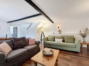 a living room with two couches and a table at Grooms Cottage Ellicombe in Dunster